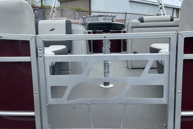 Slide: The Image of 2026 Starcraft EX 20 FD pontoon boat with maroon exterior, docked outdoors. - 16