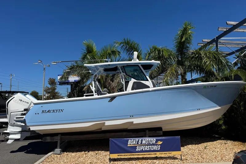 Slide: The Image of 2021 Blackfin 332 CC boat displayed at Boat & Motor Superstores, surrounded by palm trees. - 1