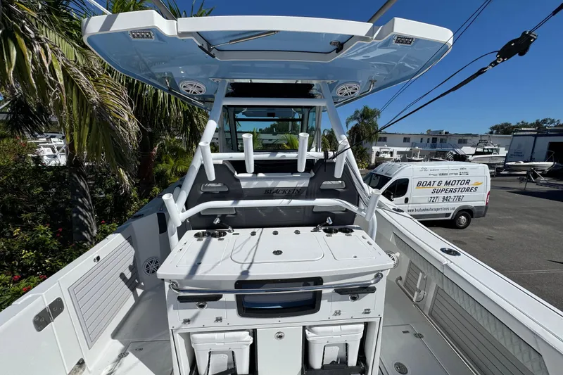 Slide: The Image of 2021 Blackfin 332 CC boat with T-top and fishing setup in a dealership lot. - 15