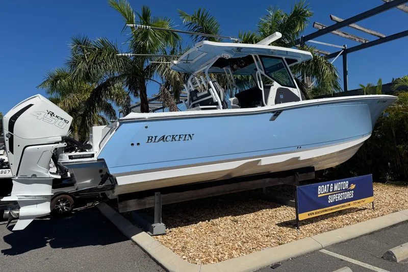 Slide: The Image of 2021 Blackfin 332 CC boat displayed outdoors with palm trees in the background. - 2