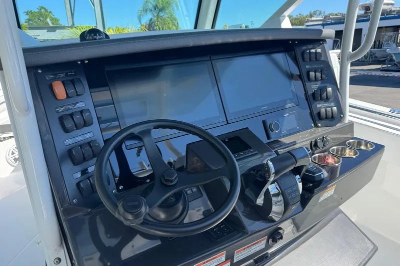 Slide: The Image of 2021 Blackfin 332 CC boat dashboard with steering wheel and control panels. - 20