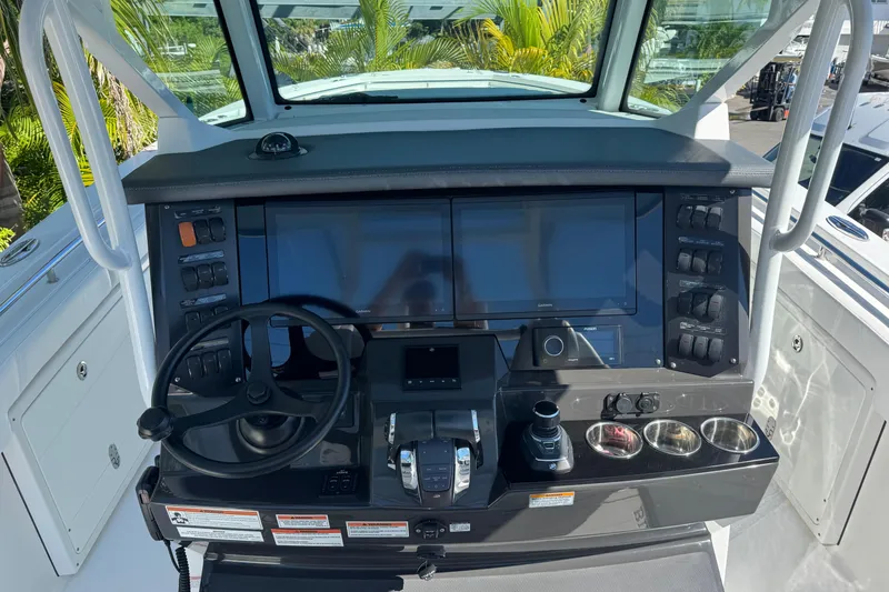 Slide: The Image of 2021 Blackfin 332 CC helm with dual screens, steering wheel, and control panel. - 21