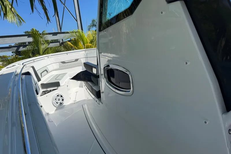 Slide: The Image of 2021 Blackfin 332 CC boat interior with seating and speaker, surrounded by tropical plants. - 23