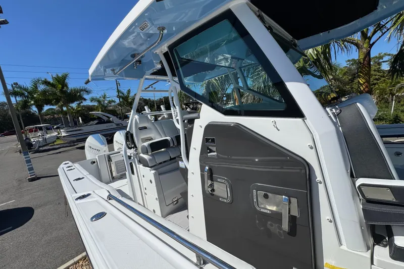 Slide: The Image of 2021 Blackfin 332 CC boat with sleek design and modern features, docked under clear skies. - 30