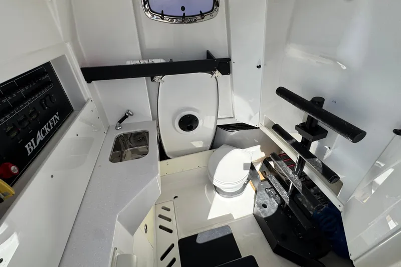 Slide: The Image of Interior of 2021 Blackfin 332 CC boat featuring a compact bathroom and sink area. - 32