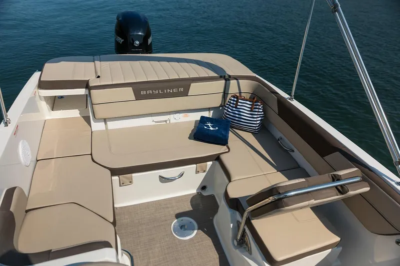 Slide: The Image of 2026 Bayliner VR6 Bowrider OB interior with beige seating, striped bag, and towel on deck. - 9
