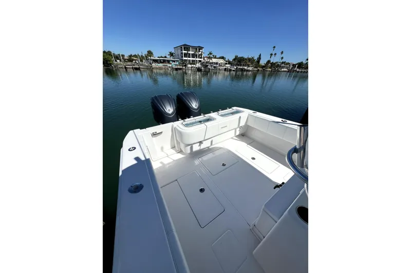 Slide: The Image of 2024 Contender 32 ST boat with dual engines on calm water, clear sky background. - 12