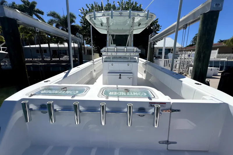 Slide: The Image of 2024 Contender 32 ST boat docked, featuring spacious deck and rod holders. - 13