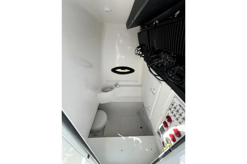 Slide: The Image of Interior of 2024 Contender 32 ST boat, featuring a compact bathroom and control panel. - 19
