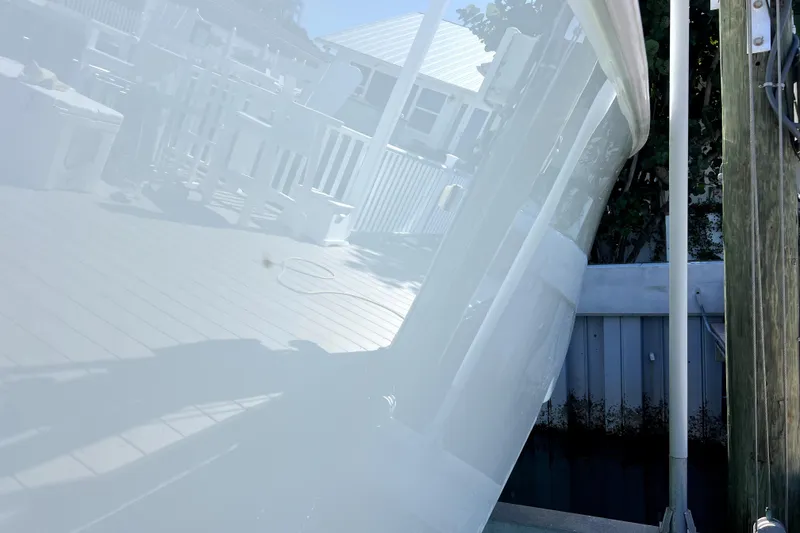 Slide: The Image of 2024 Contender 32 ST boat hull reflecting a dockside view. - 25