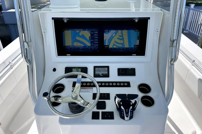 Slide: The Image of 2024 Contender 32 ST boat dashboard with dual navigation screens and steering wheel. - 7