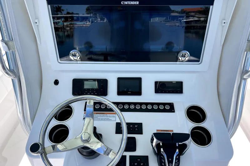 Slide: The Image of 2024 Contender 32 ST boat dashboard with steering wheel and electronic controls. - 8