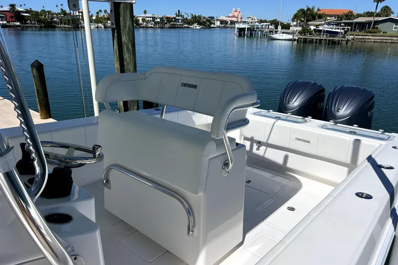 Slide: The Image of 2024 Contender 32 ST boat interior with dual engines, docked by calm waters. - 9