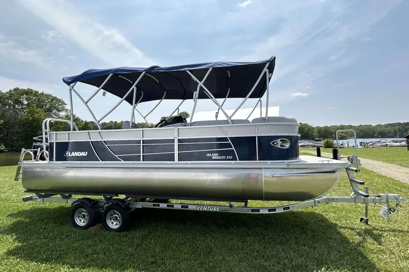 Slide: The Image of 2023 Landau Island Breeze 232 Cruise pontoon boat on trailer, parked on grass. - 12