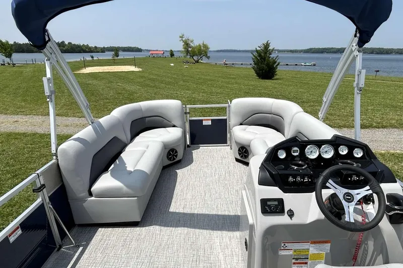Slide: The Image of 2023 Landau Island Breeze 232 Cruise pontoon boat interior with plush seating and control panel. - 6