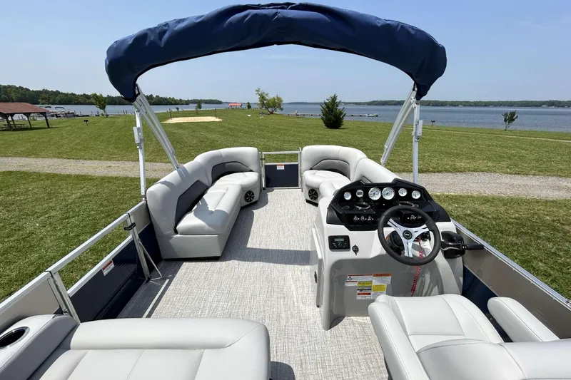 Slide: The Image of 2023 Landau Island Breeze 232 Cruise pontoon boat interior with plush seating and steering console. - 9