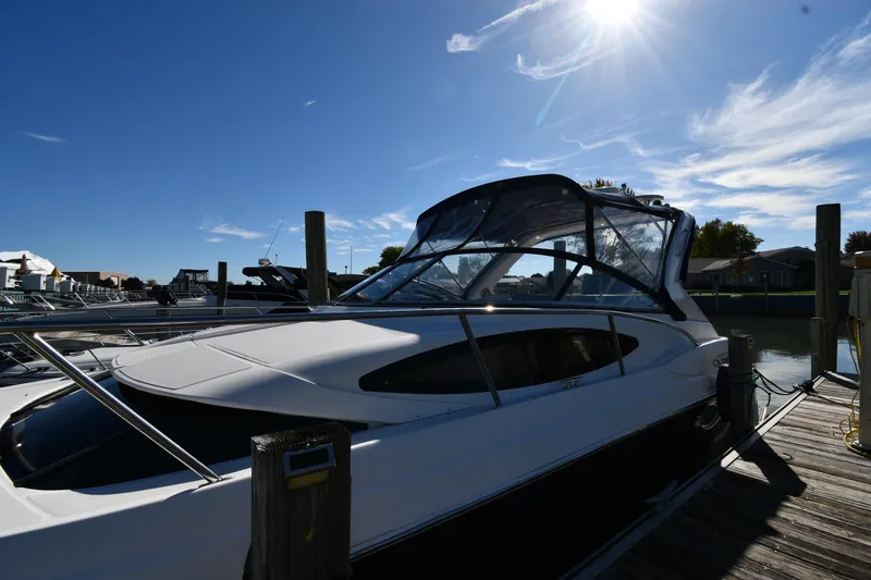 Slide: The Image of 2005 Regal 3060 Window Express boat docked under a sunny blue sky. - 1