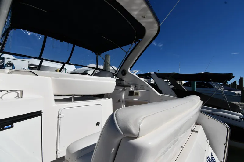 Slide: The Image of 2005 Regal 3060 Window Express boat interior with seating and dashboard under a clear blue sky. - 15