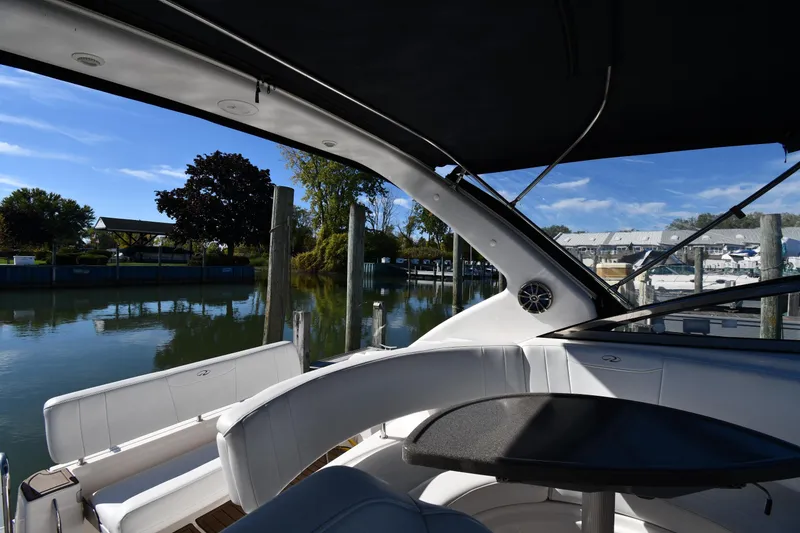 Slide: The Image of 2005 Regal 3060 Window Express boat interior at marina, featuring seating and table. - 17