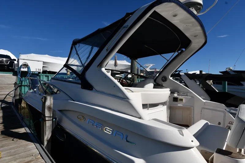 Slide: The Image of 2005 Regal 3060 Window Express boat docked at marina under clear blue sky. - 2