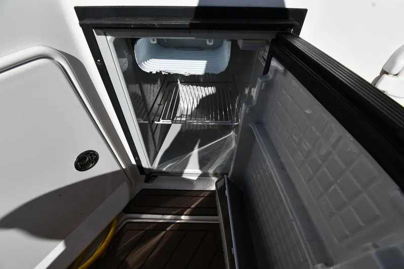 Slide: The Image of Open refrigerator on 2005 Regal 3060 Window Express boat, showing interior shelves. - 23