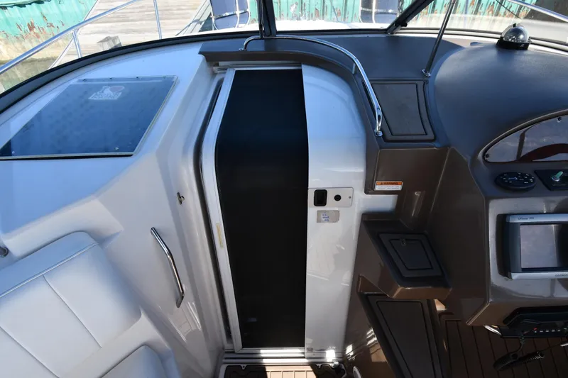 Slide: The Image of 2005 Regal 3060 Window Express boat cockpit with helm controls and seating area. - 24