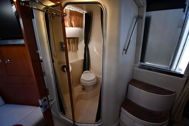 Slide: The Image of Interior of 2005 Regal 3060 Window Express boat featuring compact bathroom with toilet and shower. - 36