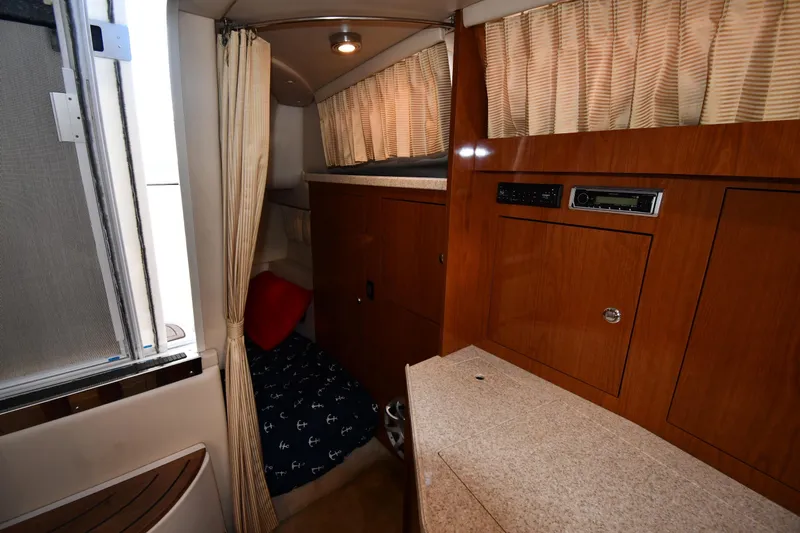 Slide: The Image of 2005 Regal 3060 Window Express cabin interior with wood finish and cozy sleeping area. - 38