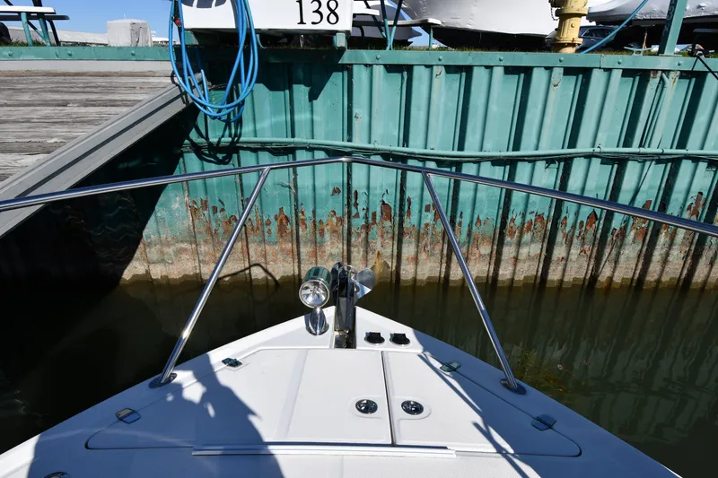 Slide: The Image of Bow view of 2005 Regal 3060 Window Express docked near a weathered metal wall. - 4