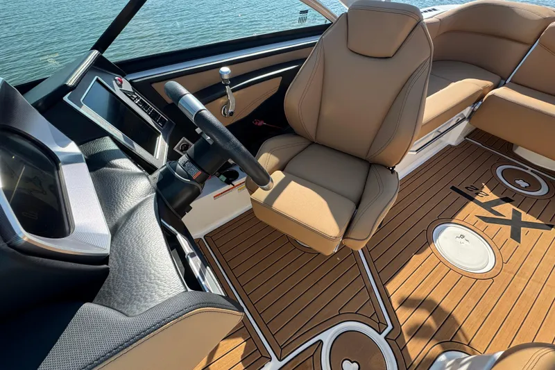 Slide: The Image of 2021 MasterCraft XT22 boat interior with tan seating and modern dashboard. - 13