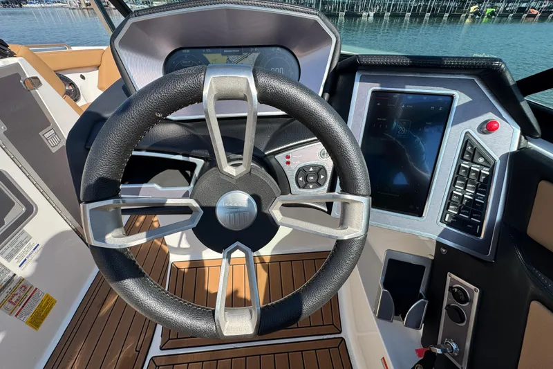 Slide: The Image of Steering wheel and dashboard of 2021 MasterCraft XT22 boat, featuring modern controls and touchscreen display. - 14