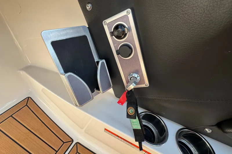 Slide: The Image of 2021 MasterCraft XT22 boat dashboard with key ignition and cup holders. - 16