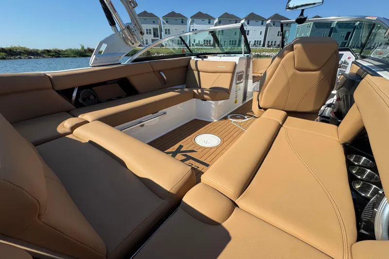 Slide: The Image of 2021 MasterCraft XT22 boat interior with tan seating and modern design. - 21