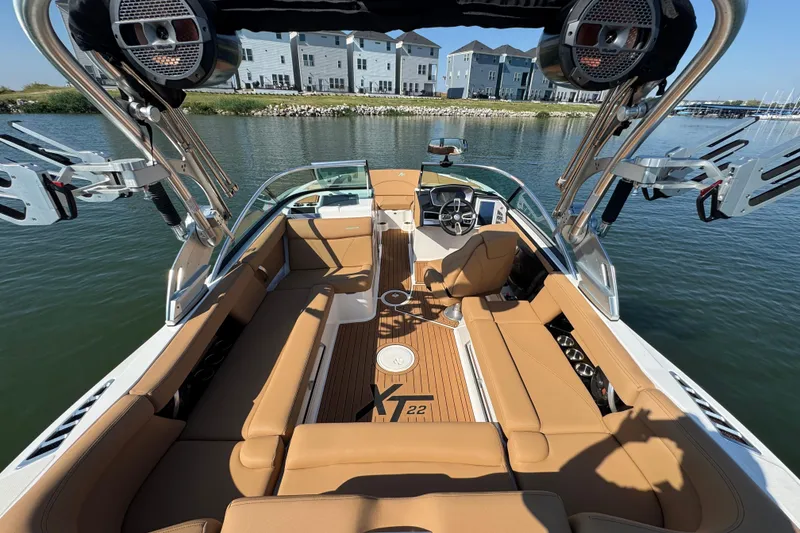 Slide: The Image of 2021 MasterCraft XT22 boat interior with tan seating, lake view, and modern design. - 23