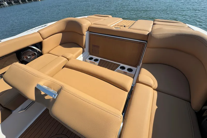 Slide: The Image of 2021 MasterCraft XT22 boat interior with tan leather seating and cup holders. - 26