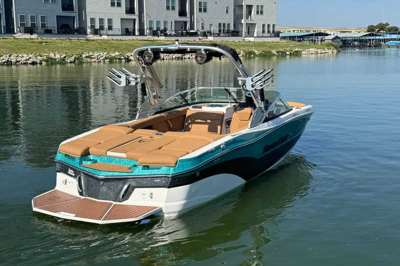 Slide: The Image of 2021 MasterCraft XT22 boat on calm water near modern buildings. - 4