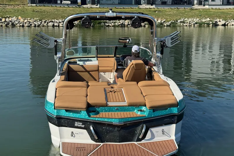 Slide: The Image of 2021 MasterCraft XT22 boat on water, featuring tan seats and teal accents. - 5