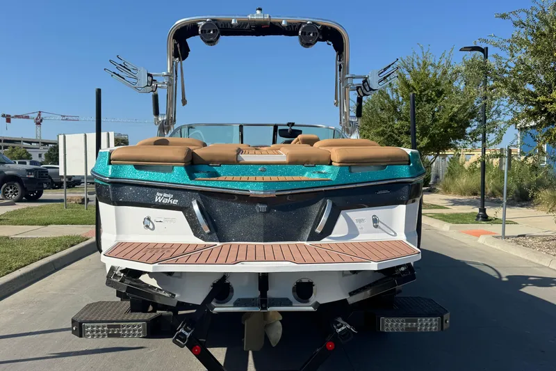 Slide: The Image of 2021 MasterCraft XT22 boat, rear view, parked on a sunny day. - 7