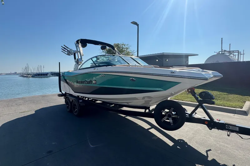 Slide: The Image of 2021 MasterCraft XT22 boat on trailer by waterfront, sunny day. - 8
