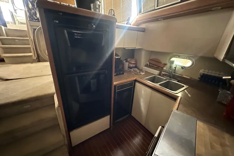 Slide: The Image of 1990 Bayliner 4388 Motoryacht interior with white seating and large windows overlooking water. - 14