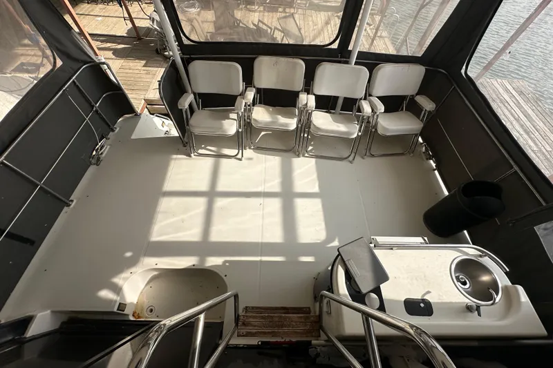 Slide: The Image of 1990 Bayliner 4388 Motoryacht deck with chairs and sink, enclosed by windows. - 15