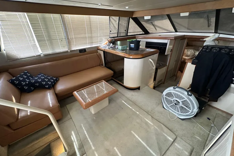 Slide: The Image of 1990 Bayliner 4388 Motoryacht interior with seating, table, and fan in cozy cabin. - 18