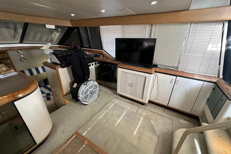 Slide: The Image of 1990 Bayliner 4388 Motoryacht interior with helm, seating, TV, and fan. - 22