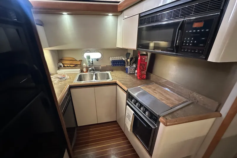Slide: The Image of 1990 Bayliner 4388 Motoryacht kitchen with modern appliances and wooden flooring. - 23