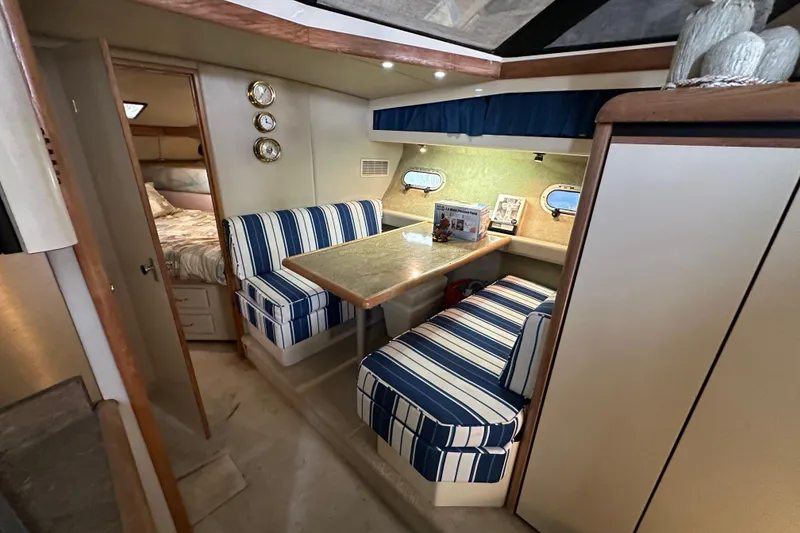 Slide: The Image of Interior of 1990 Bayliner 4388 Motoryacht with striped seating and cozy dining area. - 26