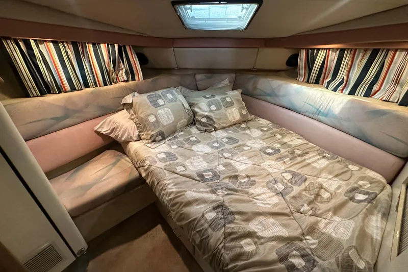 Slide: The Image of Cozy bedroom in 1990 Bayliner 4388 Motoryacht with patterned bedding and striped curtains. - 28