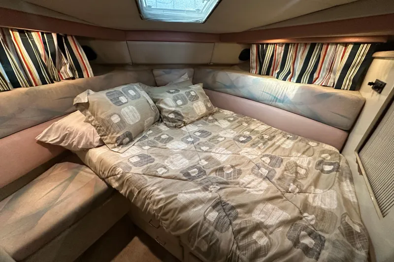 Slide: The Image of Cozy bedroom in 1990 Bayliner 4388 Motoryacht with patterned bedding and striped curtains. - 29