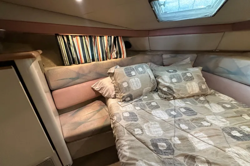 Slide: The Image of Cozy bedroom in 1990 Bayliner 4388 Motoryacht with patterned bedding and striped curtains. - 30
