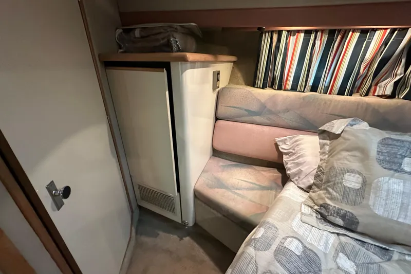 Slide: The Image of 1990 Bayliner 4388 Motoryacht interior cabin with bed, striped curtains, and storage. - 32