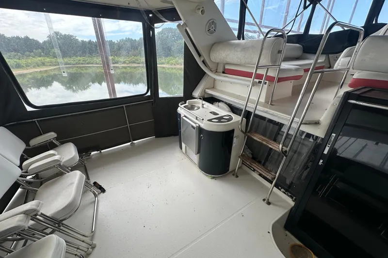 Slide: The Image of 1990 Bayliner 4388 Motoryacht docked under a covered marina. - 4